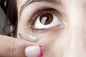 woman holding contact lenses